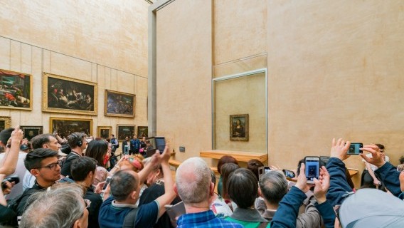 Tourism should help prop up the French economy this the summer. Pictured: Tourists snapping the Mona Lisa in the Louvre, Paris Source: