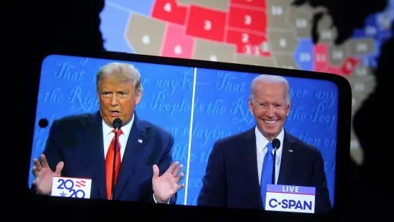 In this photo illustration the US President Donald Trump and Democratic presidential candidate Joe Biden are seen during the final presidential debate displayed on a screen of a smartphone.