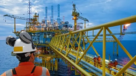 A worker inspects an offshore oil rig