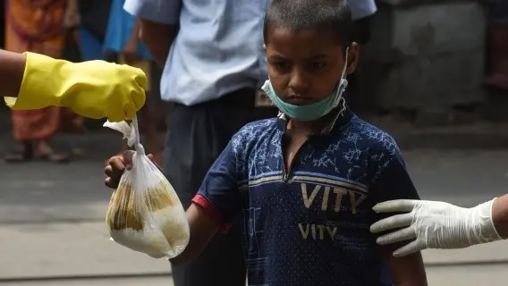 A child receives a food parcel in India