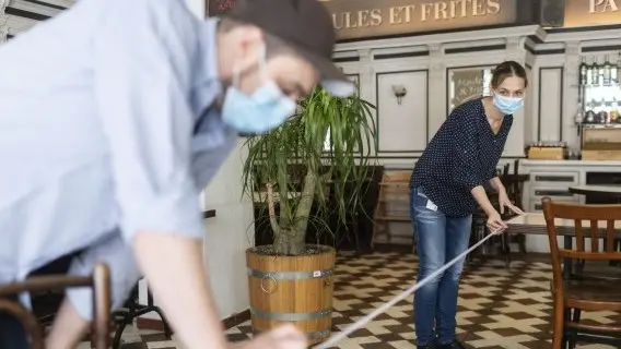 Staff in a Zurich restaurant prepare to reopen but tables are more spread out