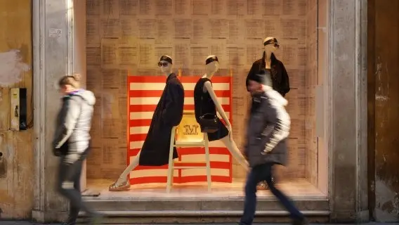 People walk past a store in Rome, Italy