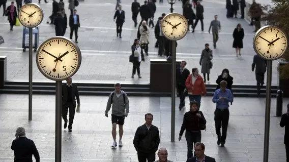 Present bias - Pedestrians walking along Six Public Clocks in Canary Wharf