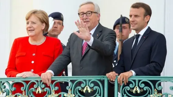 German Chancellor Angela Merkel, left, and French President Emmanuel Macron, right, welcome the President of the European Commission Jean-Claude Junker. June 2018