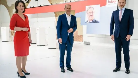 Top candidates for the upcoming federal elections (L-R) Annalena Baerbock (Green Party), Olaf Scholz (SPD), Christian Lindner (FDP) pose in front of a picture of Armin Laschet (CDU) for photographers prior to a discussion board in Berlin, Germany
