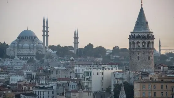 The historic Galata Tower rises over the skyline at dusk, Istanbul