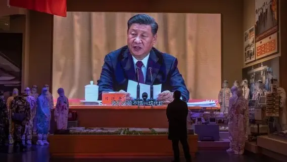 A visitor looks at a screen showing Chinese President Xi Jinping, at the Museum of the Communist Party of China in Beijing