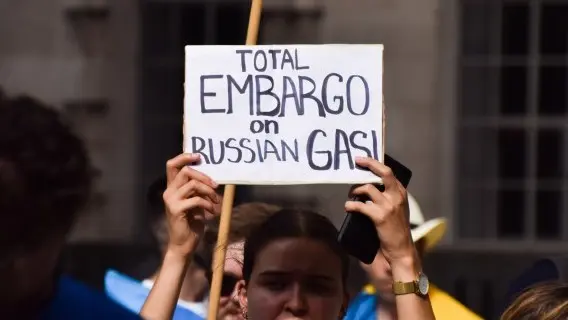 A protester outside Downing Street holds a sign calling for a total embargo on Russian gas