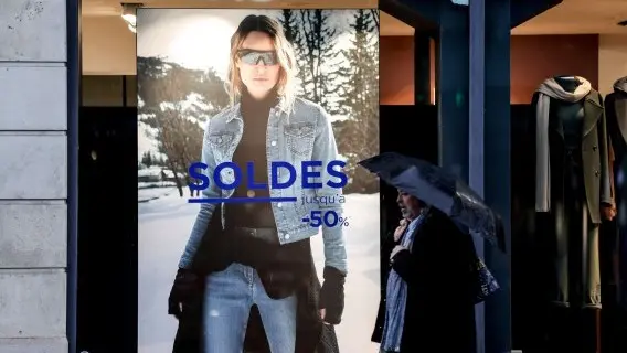 A man walks past a store having a sale in Paris