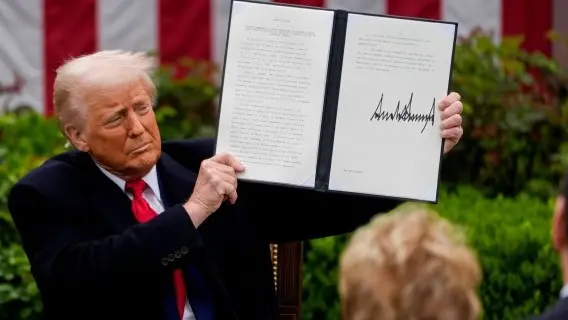 President Donald Trump holds up a signed executive order on global US tariffs