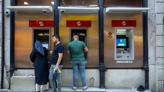 People withdrawing money from an ATM in Istanbul, Turkey, where the central bank has held interest rates steady 37%